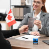 Provincial Nominee Program Canada: A picture showing an Embassy worker handing over passport to a successful PNP applicant.