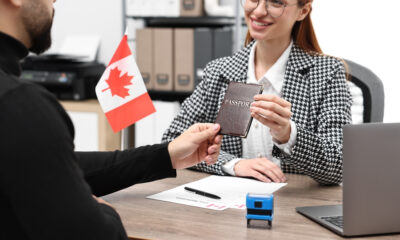 Provincial Nominee Program Canada: A picture showing an Embassy worker handing over passport to a successful PNP applicant.