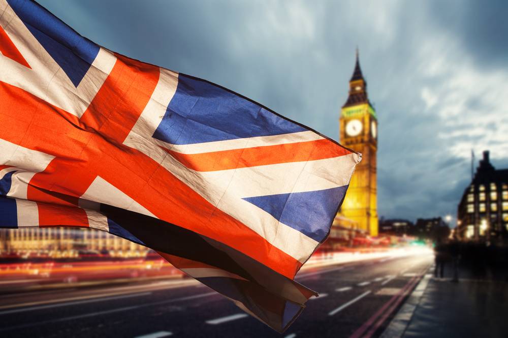 Ways You Can Travel to the UK in 2024: A picture showing union jack flag and iconic Big Ben at the palace of Westminster, London - the UK