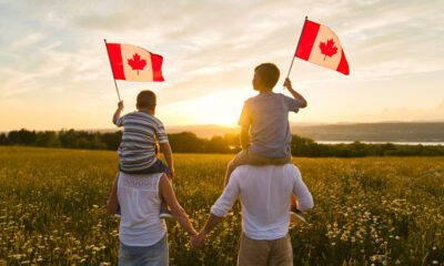 Canada Family Reunion Visa: A picture showing a couple with their kids holding Canadian flags.