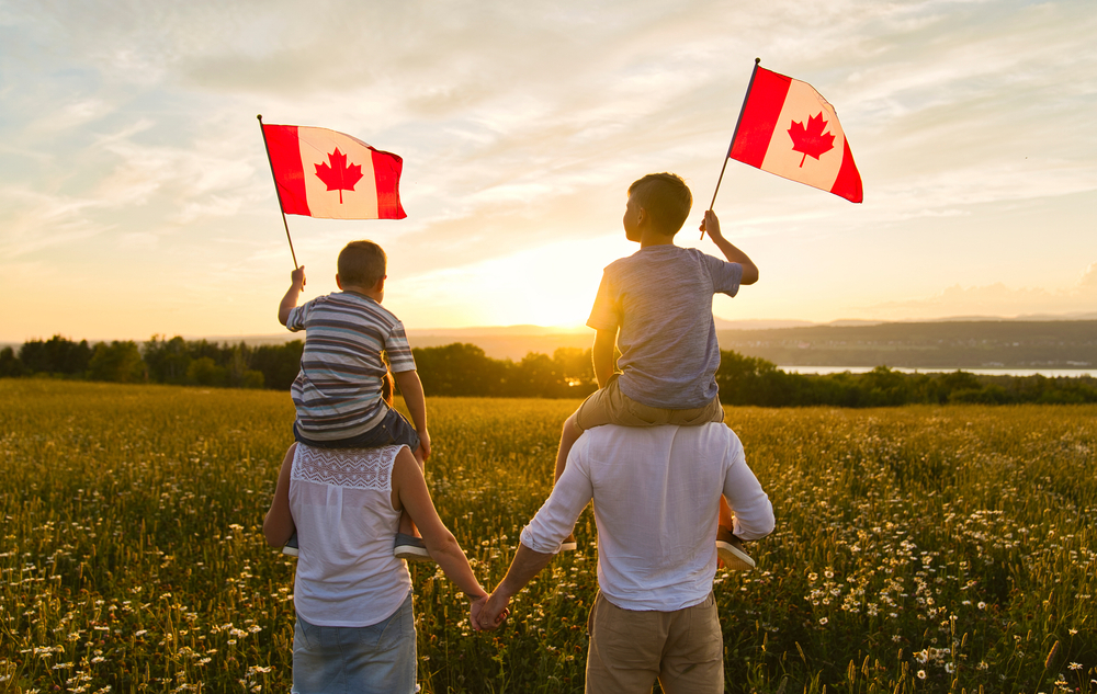 Canada Family Reunion Visa: A picture showing a couple with their kids holding Canadian flags.