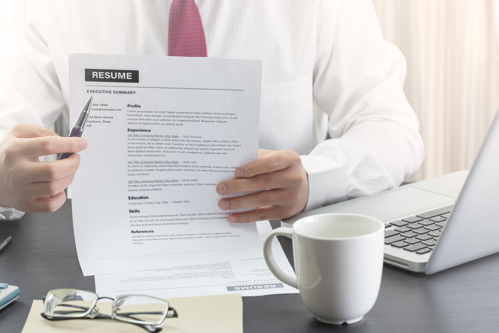 Worst Rookie Errors for First-Time UK Job Seekers: A picture showing a recruiter pointing pen to a paper resume of a job seeker.