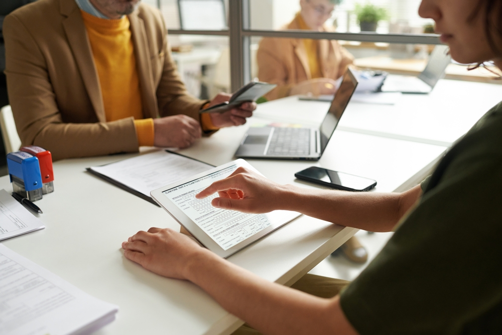 Canada Visa Appointment: A picture showing a consular and an applicant filling information on tab during visa appointment.