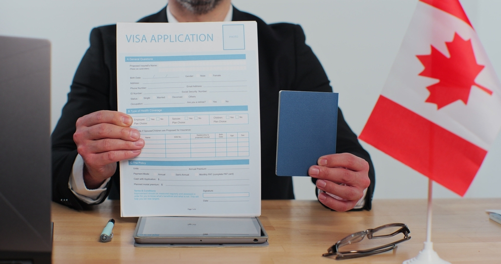 Canada Student Visa Requirements: A picture showing a consular officer displaying Canada visa application form and passport.