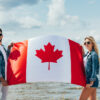 Canada Permanent Residency: A picture showing a Canada couple holding Canadian flag after securing permanent Residency.