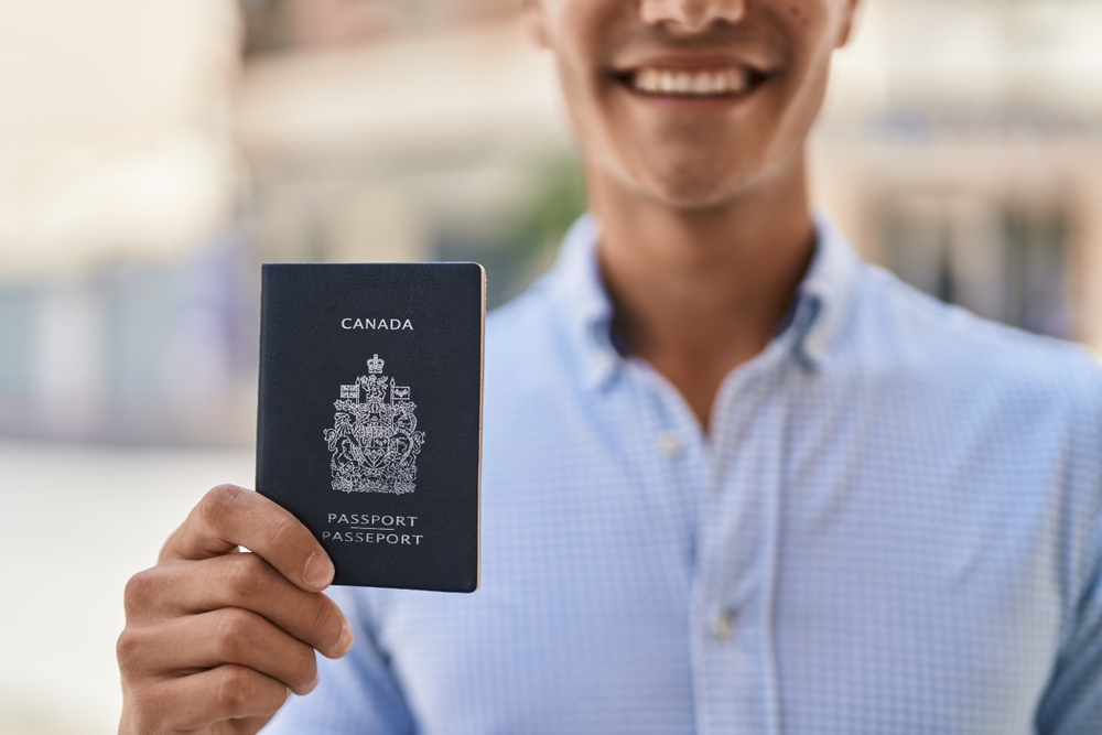 Canada Citizenship: A picture showing a man displaying Canada passport.