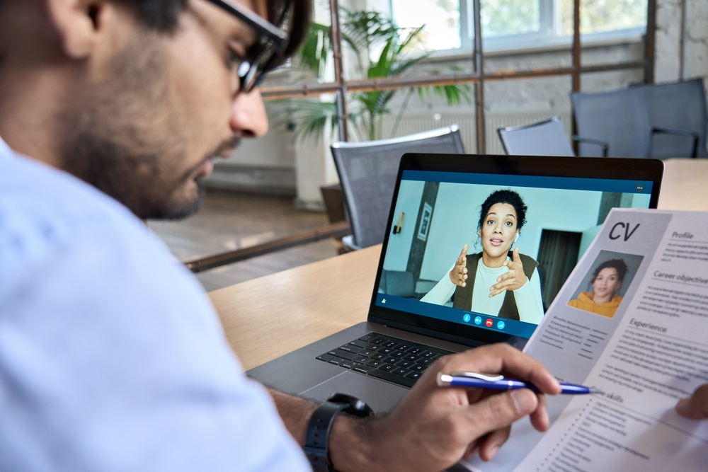 Remote job at Sutherland global: human resource manager holding cv having virtual job interview conversation with remote female candidate during distant business video call on laptop computer