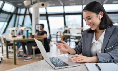 The Essential Guide to Remote Job Performance Reviews: Picture of a smiling lady working on a laptop