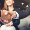 UK Workplace Etiquette Mistakes That Could Cost You: Picture of businessmen making handshake with his partner in cafe - business etiquette, congratulation, merger and acquisition concepts.