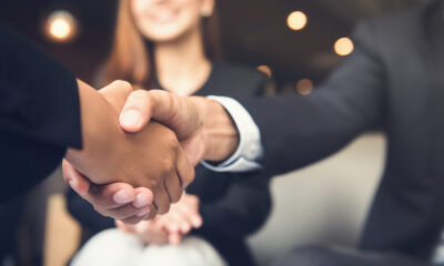 UK Workplace Etiquette Mistakes That Could Cost You: Picture of businessmen making handshake with his partner in cafe - business etiquette, congratulation, merger and acquisition concepts.