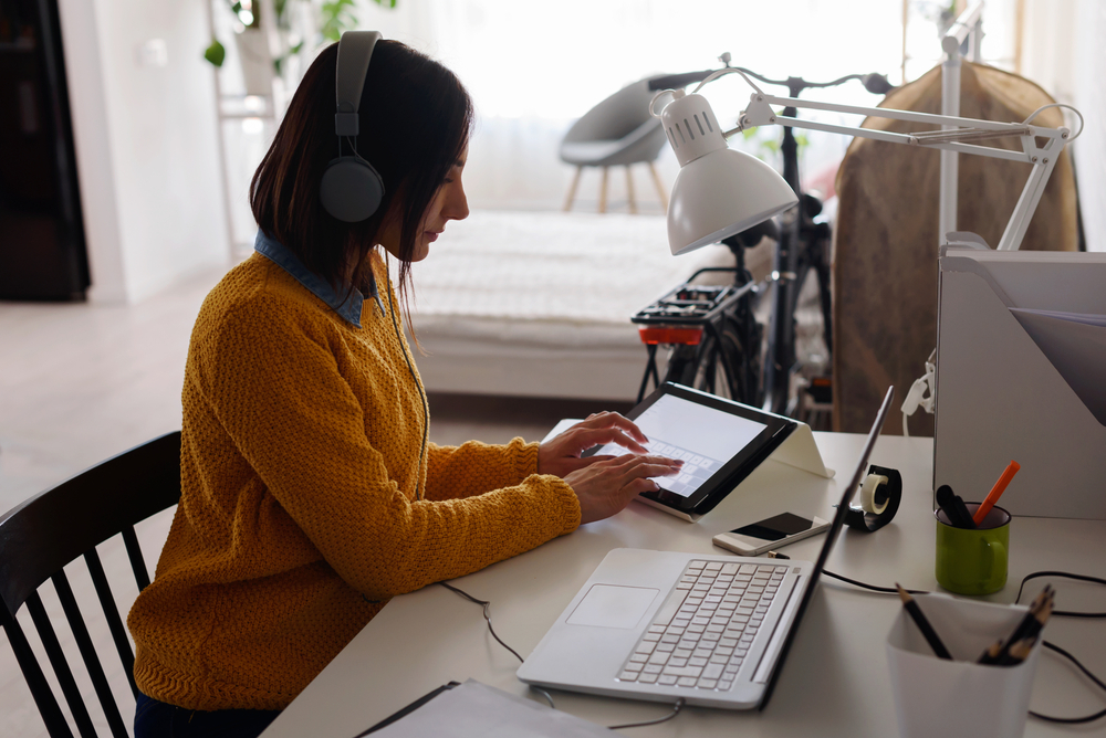 Things to Know Before Relocating for a Remote Job: Picture of a female freelancer working remotely on a laptop. 