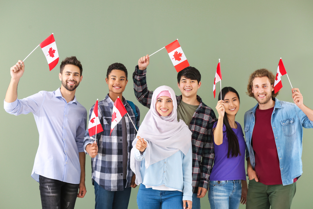 Mistakes People Make When Applying for a Canada Visa: A picture showing a group Canadian students holding the country's flag