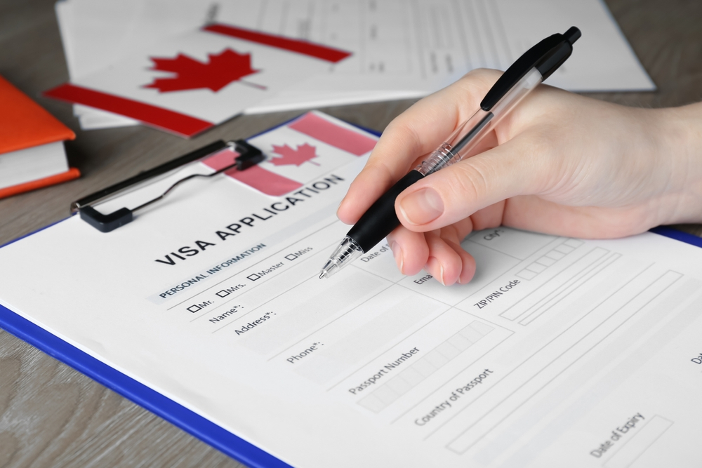 Mistakes People Make When Applying for a Canada Visa: A picture showing a Canada visa applicant filling out the application.