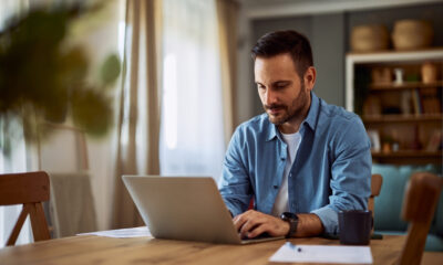The Essential Guide to Remote Job Performance Reviews: Picture of a focused male freelancer working remotely from home.