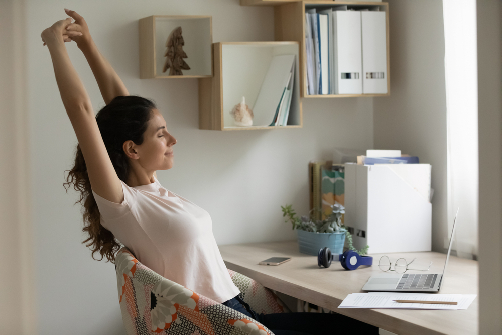 Proven Strategies to Avoid Distractions When Working Remotely: A serene female freelancer relaxing after a long time of distant learning by laptop at home office.