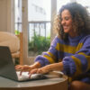 Work from Home Pitfalls and How to Avoid Them: Picture of a happy lady working remotely on a laptop.