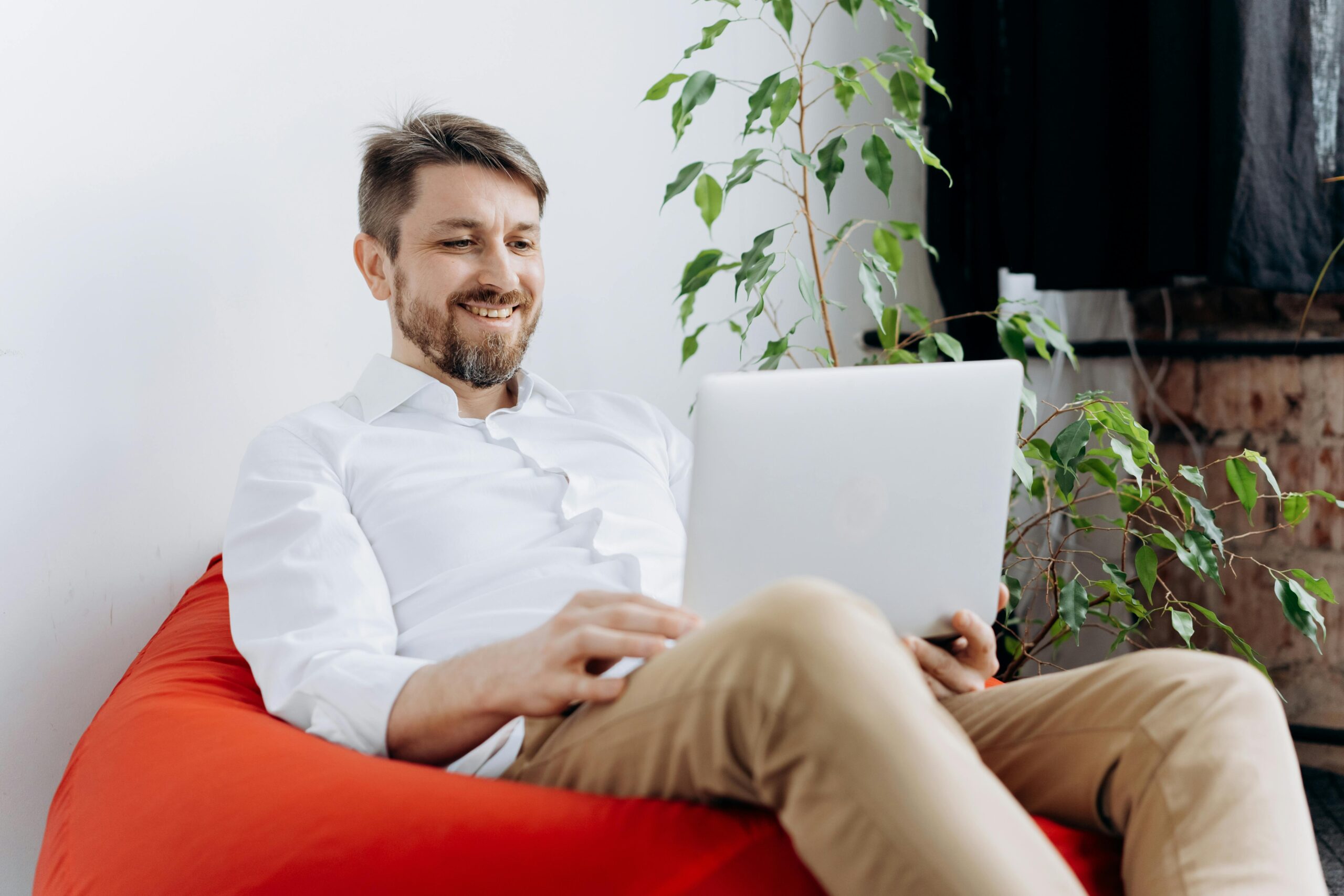 The Biggest Mistakes People Make When Interviewing for Remote Positions: A happy man working remotely from home on a laptop