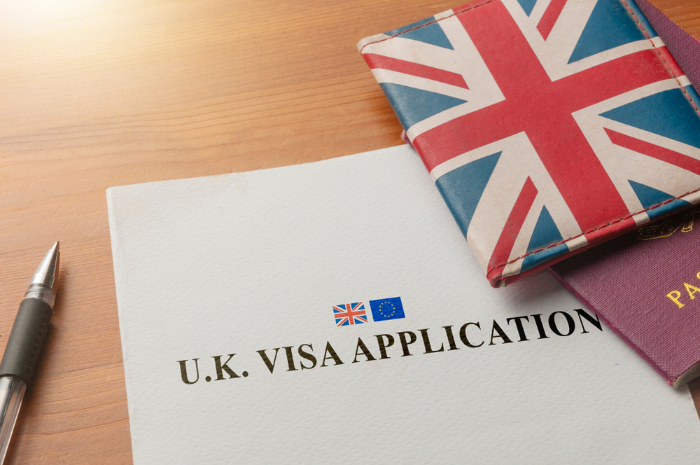 In-Person vs Virtual UK Visa Appointments: Visa application on desktop with passport and union jack wallet 