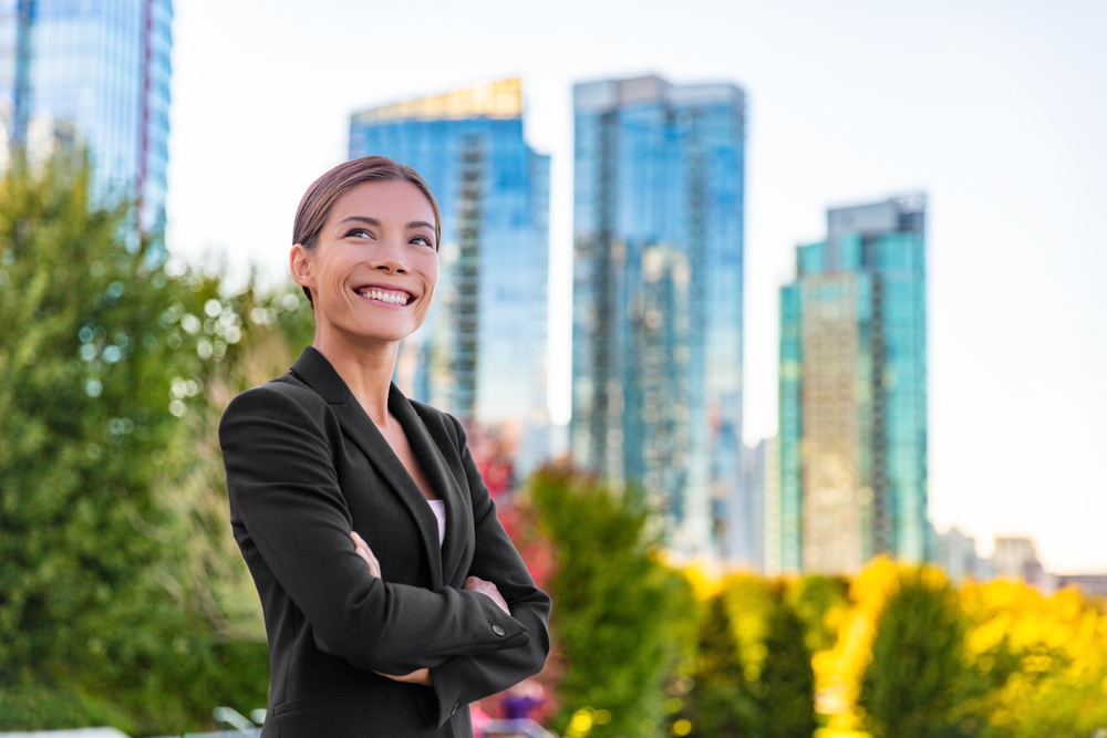 Toronto vs Vancouver: Picture of a young happy lady wearing a professional suit. 