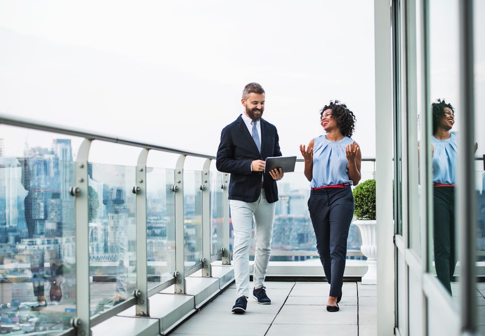 Best and Worst Canadian Provinces for Job Opportunities: A portrait of two businesspeople standing against London view panorama.