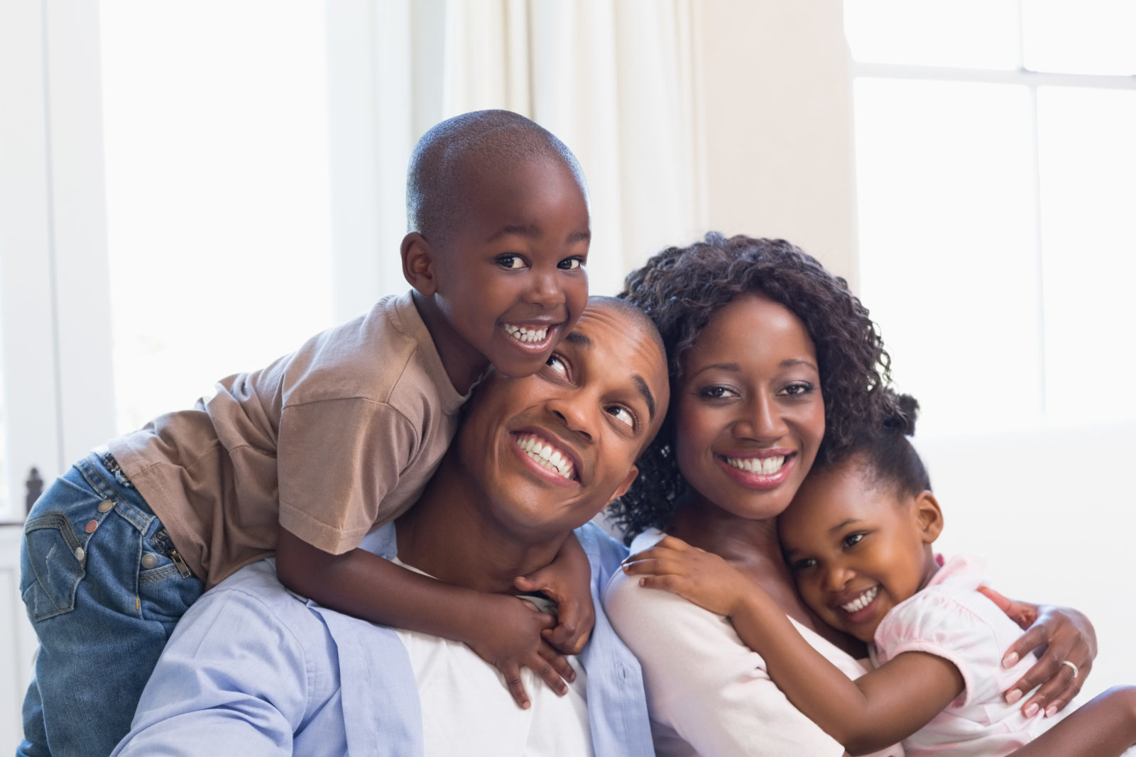 How This Family Saved Thousands by Choosing the Right City to Live in Canada: Happy family posing on the couch together at home in the living